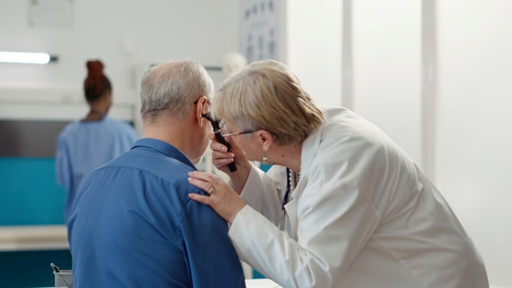 Otolaryngology specialist using otoscope to examine ear infection, helping patient with disease